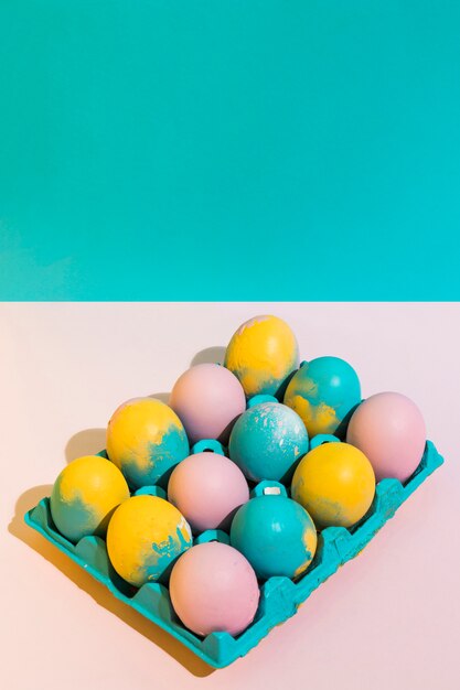 Oeufs de Pâques lumineux dans un support sur la table rose