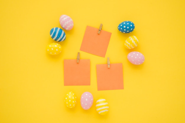 Oeufs de Pâques avec petits papiers vierges sur table