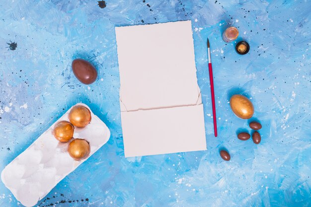 Oeufs de Pâques en rack avec pinceau et papier