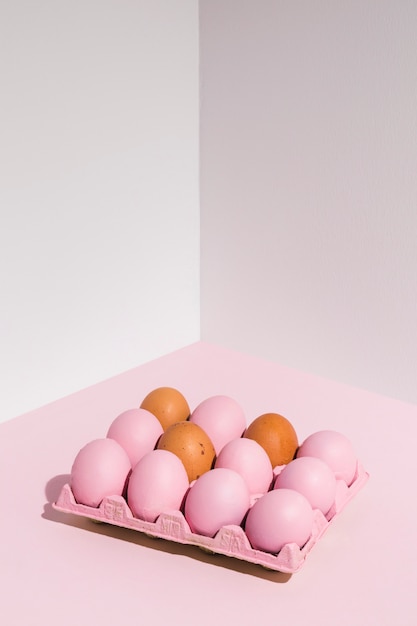 Oeufs de Pâques en rose sur une table lumineuse