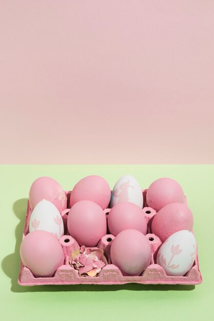 Oeufs de Pâques roses dans un grand rack sur la table