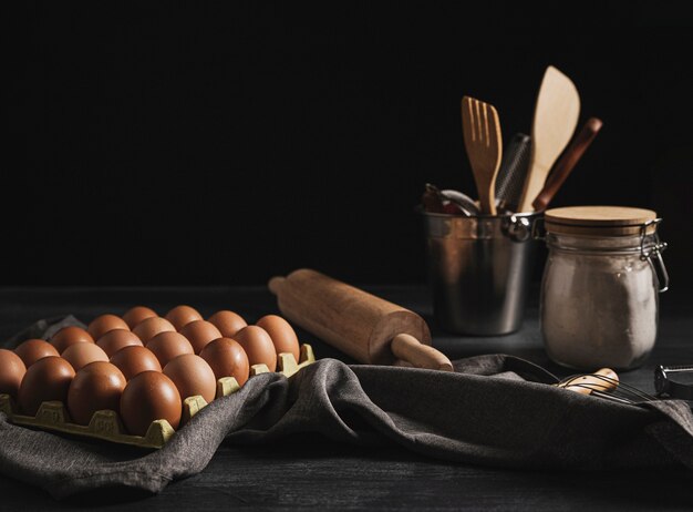 Oeufs vue de face près des ustensiles de cuisine