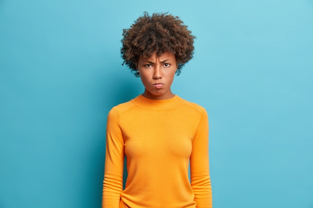 Photo gratuite offensé insatisfait jeune femme écoute les excuses de son petit ami regarde avec une expression mécontente de mauvaise humeur à la caméra étant déçu par quelque chose d'isolé sur le mur bleu