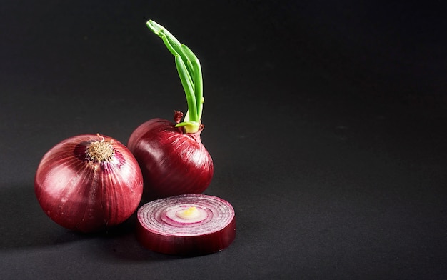 Oignons rouges entiers, isolés sur fond noir