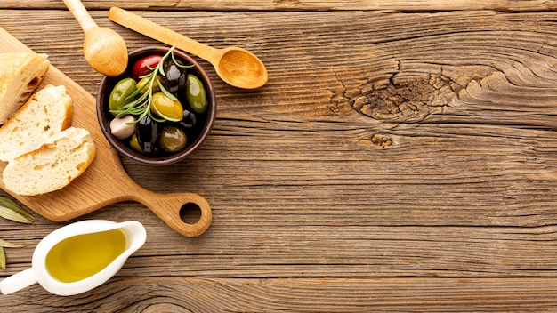 Olives à angle élevé mélangent des bouteilles de pain et d’huile avec un espace de copie