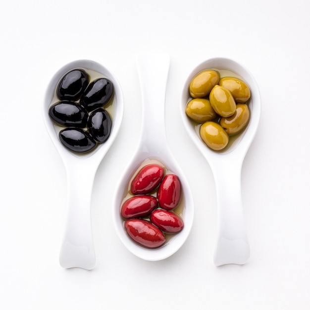 Photo gratuite olives rouges noires jaunes en cuillères