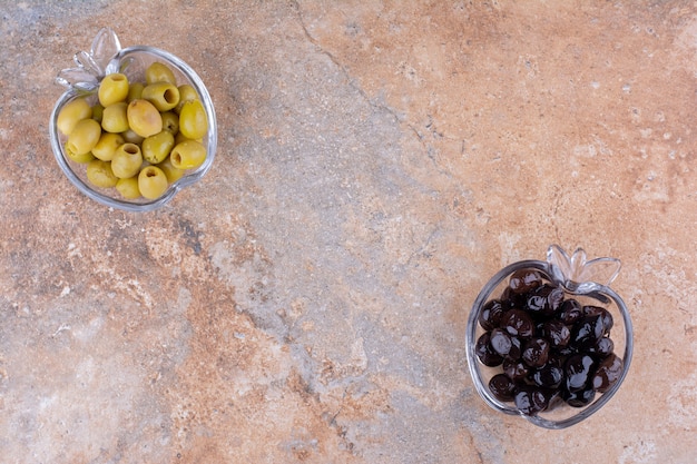 Olives vertes et noires dans des coupes en verre