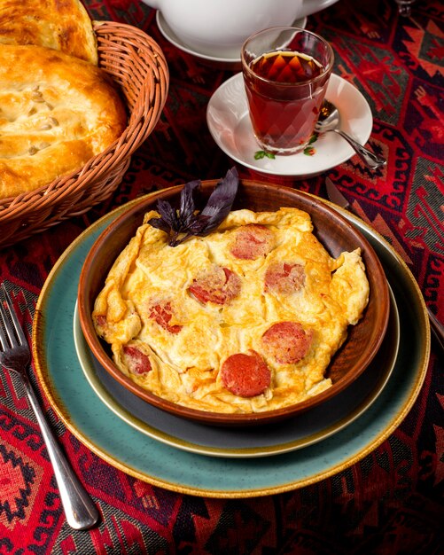 Omelette aux œufs frits avec saucisse sur la table