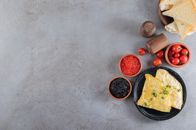 Omelette aux tranches de pain et caviar rouge et noir.