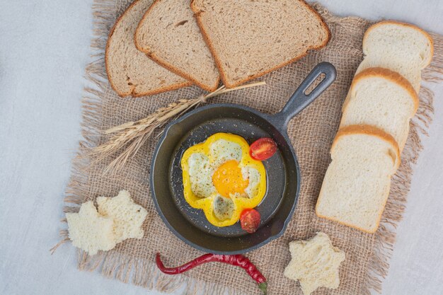 Omelette avec des tranches de pain blanc sur un sac.