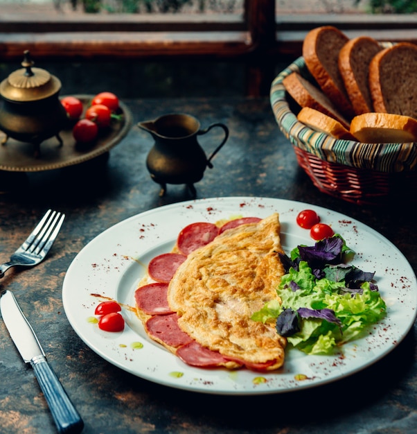 Photo gratuite omlette au pepperoni et salade verte.