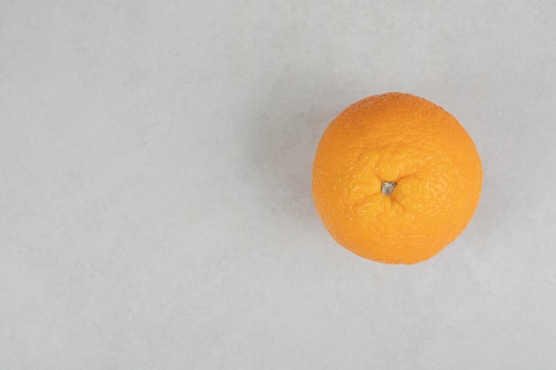 Orange entière fraîche sur une surface grise