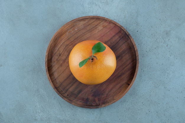 Orange juteuse mûre sur une plaque en bois, sur le fond de marbre. photo de haute qualité