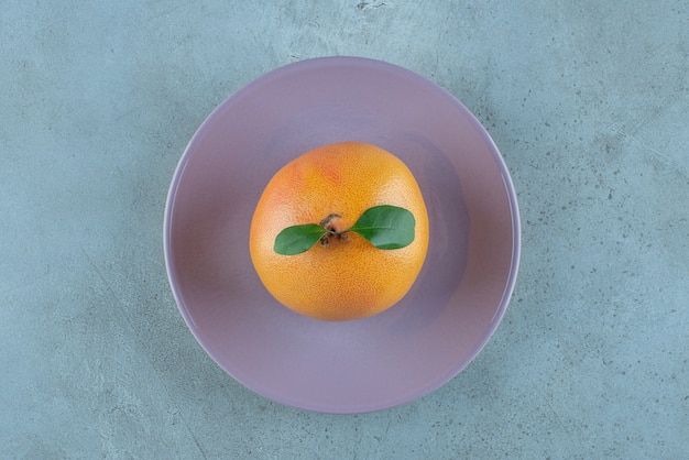 Orange mûre fraîche sur une assiette, sur le fond de marbre. photo de haute qualité