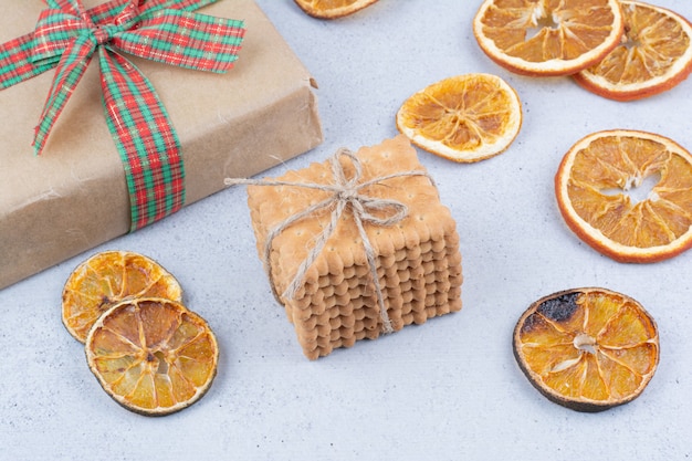 Photo gratuite orange séchée, biscuits et boîte-cadeau sur fond de marbre.