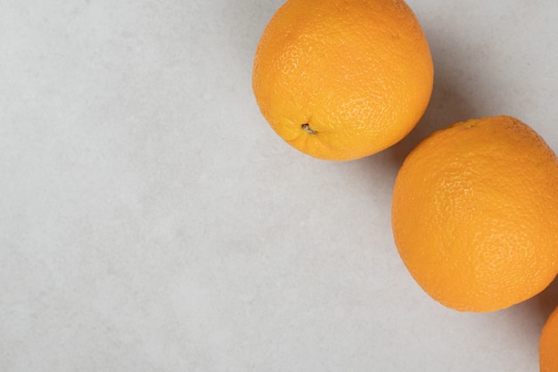 Oranges entières juteuses sur une surface grise