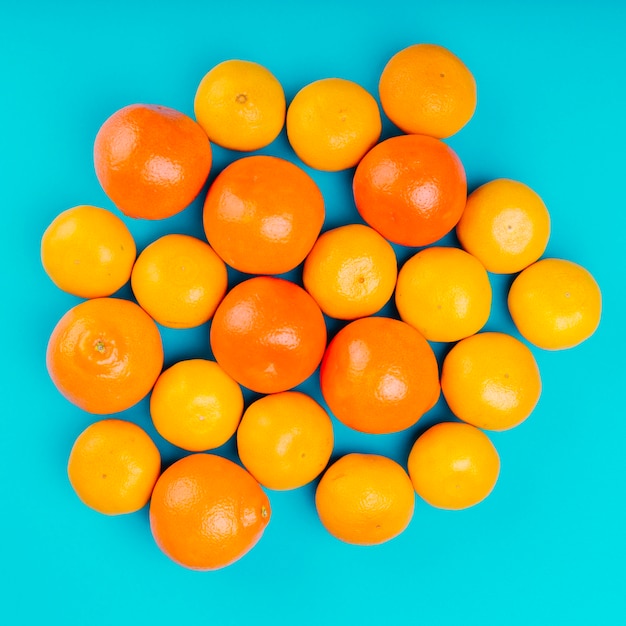 Photo gratuite oranges entières mûres sur fond turquoise