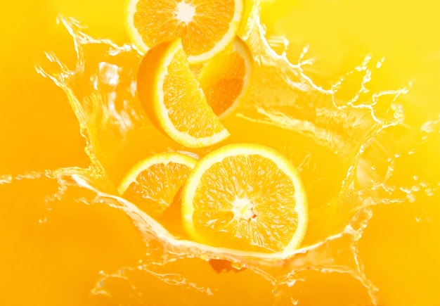 Oranges fraîches tombant dans le jus