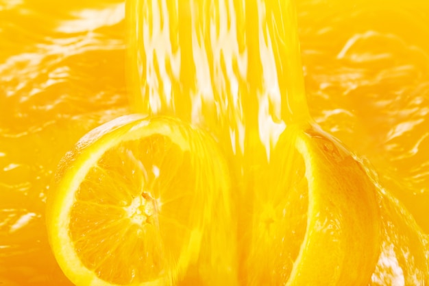 Oranges fraîches tombant dans le jus