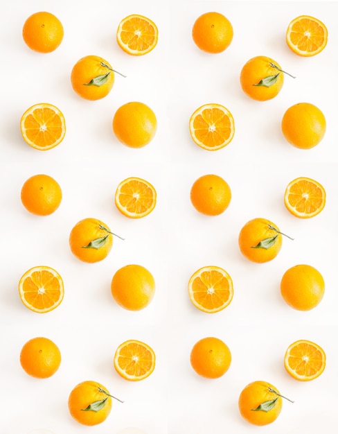 Photo gratuite oranges tranchées et entières sur une surface claire