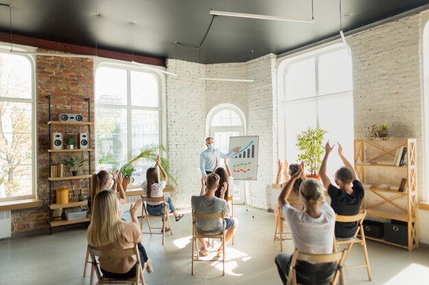 Orateur masculin donnant une présentation dans le hall à l'atelier universitaire. Salle d'audience ou de conférence