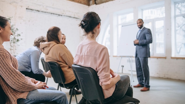 Orateur masculin donnant une présentation dans le hall à l'atelier universitaire. Salle d'audience ou de conférence