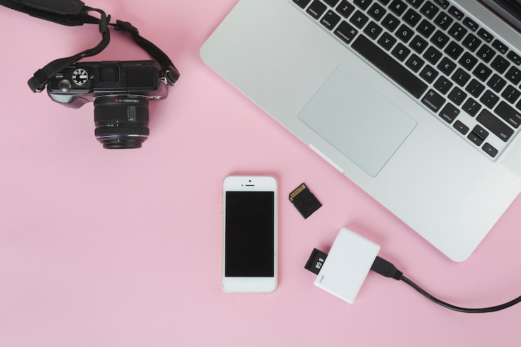 Photo gratuit ordinateur portable avec caméra et carte sd sur table rose
