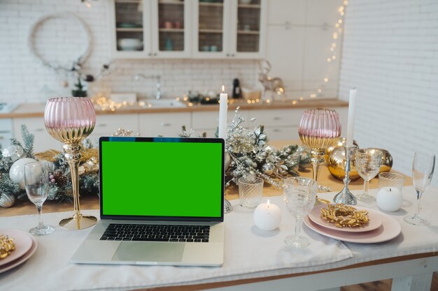 Ordinateur portable avec écran vert - chromakey près des décorations du Nouvel An. thème de Noël. modèle.