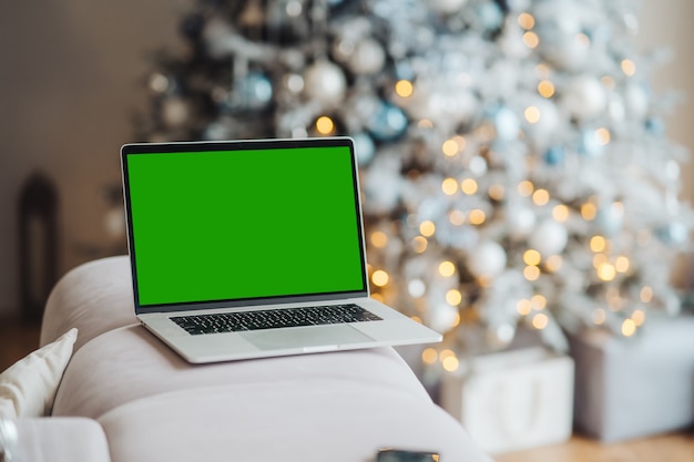 Ordinateur portable avec écran vert chromakey près du thème de Noël décorations du nouvel an