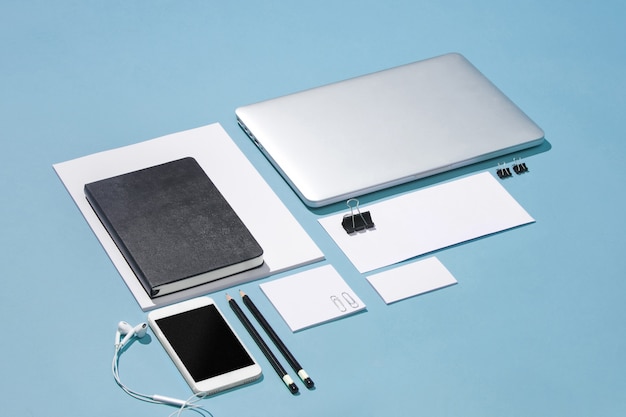 ordinateur portable, stylos, téléphone, note avec écran vide sur table