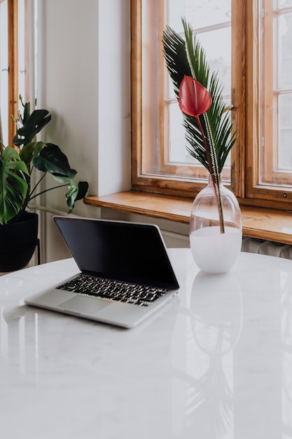 Ordinateur portable et un vase sur une table de marbre