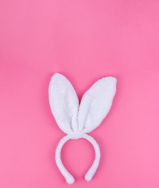 Oreilles de lapin blanc sur fond rose