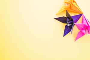 Photo gratuite origami fleurs en papier coloré sur fond jaune