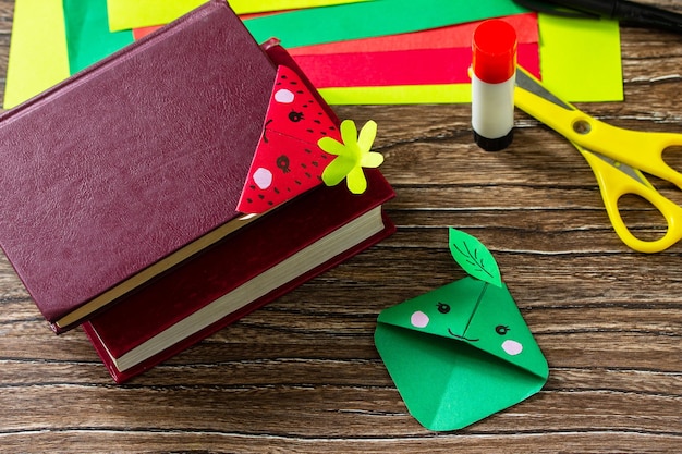 Origami D'un Signet En Papier Pour Livres Une Fraise Et Une Pomme Sur Une Table En Bois Photo Premium