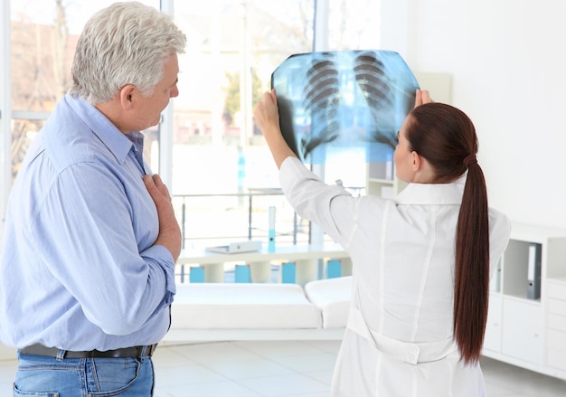 Orthopédiste féminine examinant un homme âgé en clinique