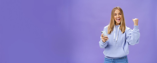 Oui, Nous L'avons Fait, Une Femme Excitée En Sweat à Capuche Levant Le Poing En Signe De Célébration Et De Succès