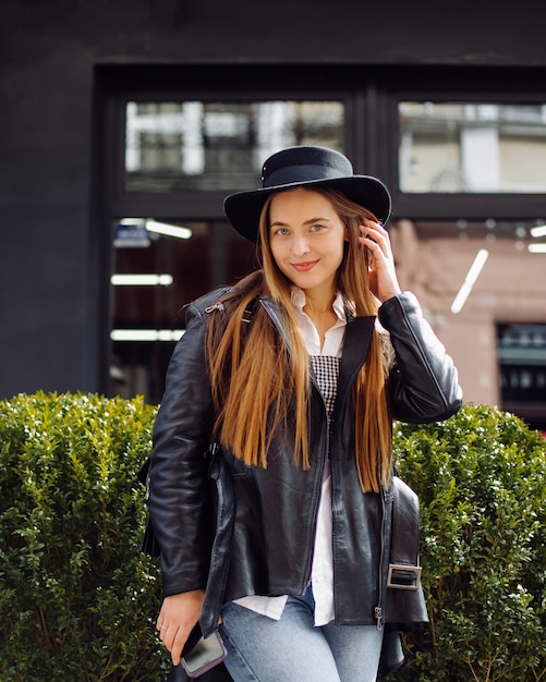 Ã Â oung jolie fille se promène dans la ville en souriant et posant