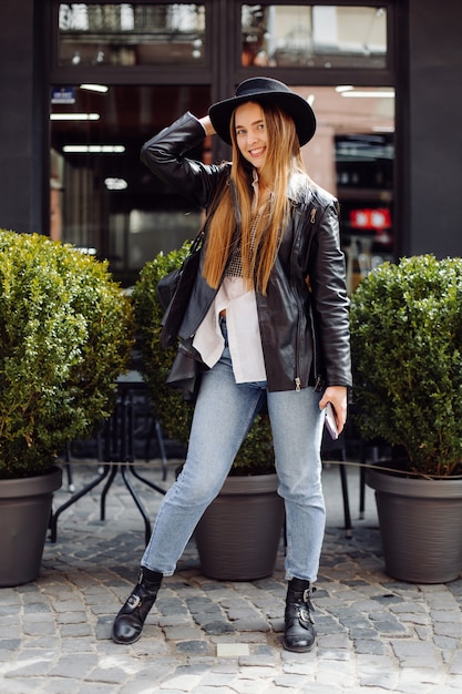 Photo gratuite Ã â oung jolie fille se promène dans la ville en souriant et posant