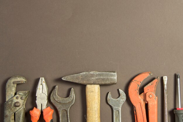 Outils de construction sur papier grunge texturé composé d'une clé à pipe, d'un tournevis, d'un métal, d'un marteau et d'un espace de copie gratuit sur le dessus