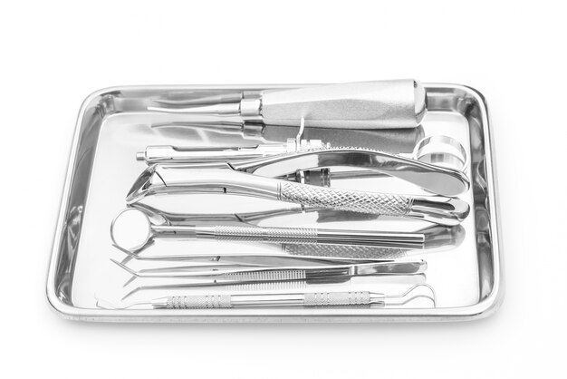 Outils et équipements dentaires sur fond blanc.