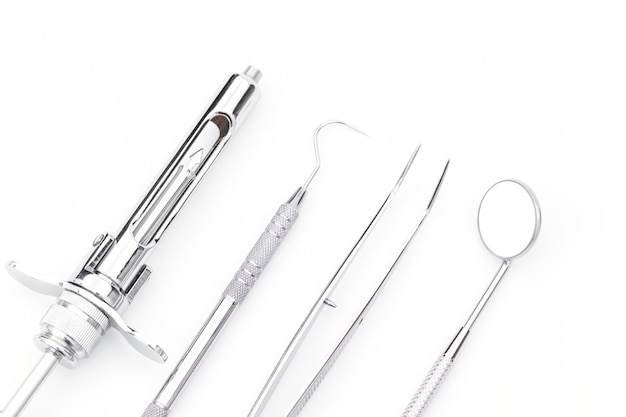Outils et équipements dentaires sur fond blanc.
