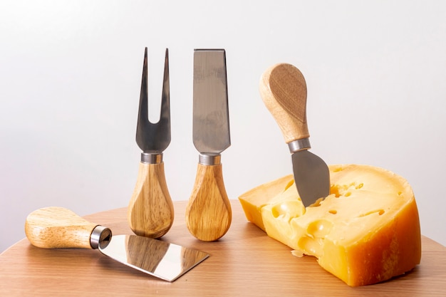 Outils de gros plan avec une tranche de fromage sur une table