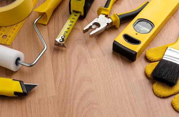 Outils de réparation jaune haute vue sur fond de bois