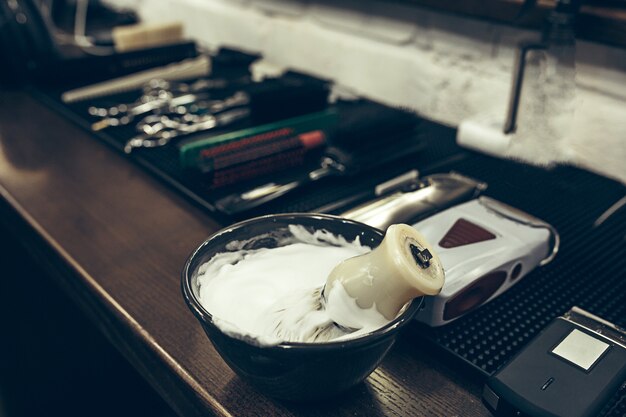 Outils de salon de coiffure sur la table. Bouchent la mousse à raser.