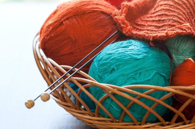 Outils de tricotage et boules de fil dans un panier