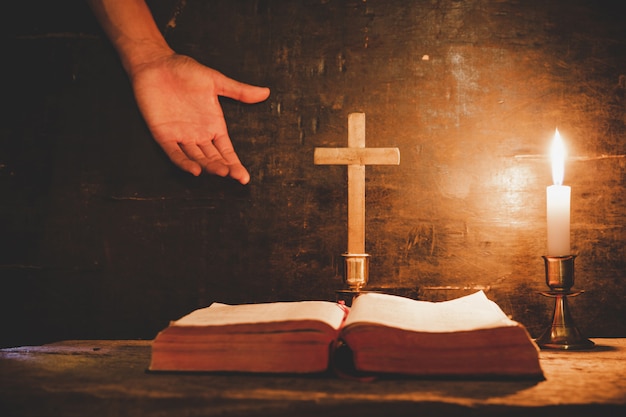 Ouvrez la Sainte Bible et bougie sur une vieille table en bois de chêne.