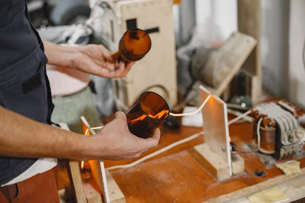 Ouvrier avec bouteille vide. Gros plan de la main de l'homme.Le concept de production.