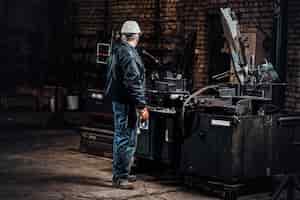 Photo gratuite un ouvrier expérimenté travaille dans une usine métallurgique à l'aide d'une machine-outil spéciale.