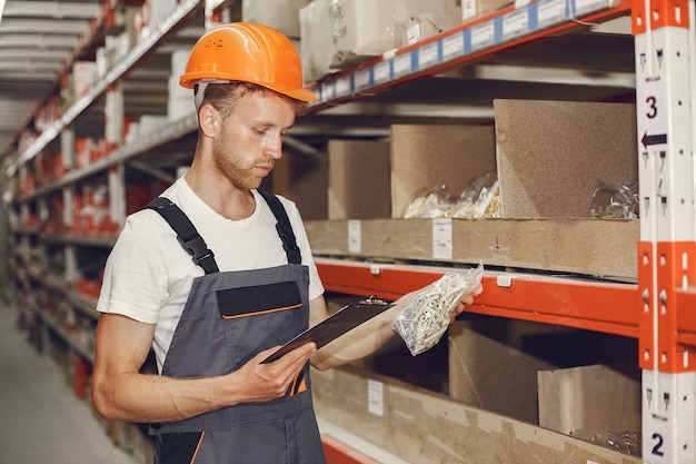 Photo gratuite ouvrier industriel à l'intérieur en usine. jeune technicien avec casque orange.