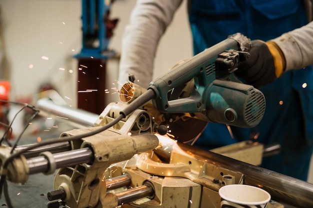 Ouvrier travaillant avec une meuleuse circulaire sur un métal avec des étincelles